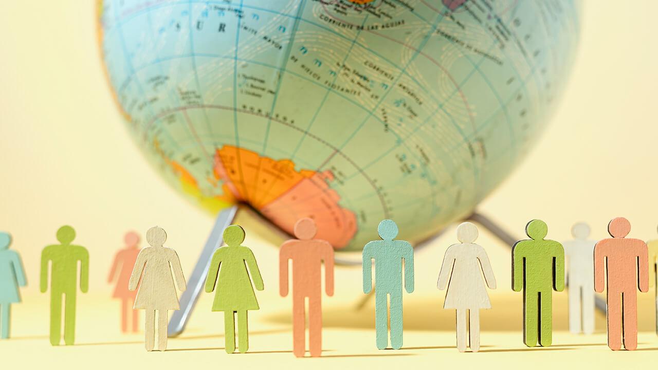 A imagem mostra bonecos de diversas cores em frente a um globo, em referências aos negócios sociais.