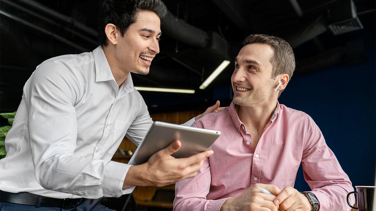 Dois homens de negócio conversando, um deles atuando como assistente administrativo.