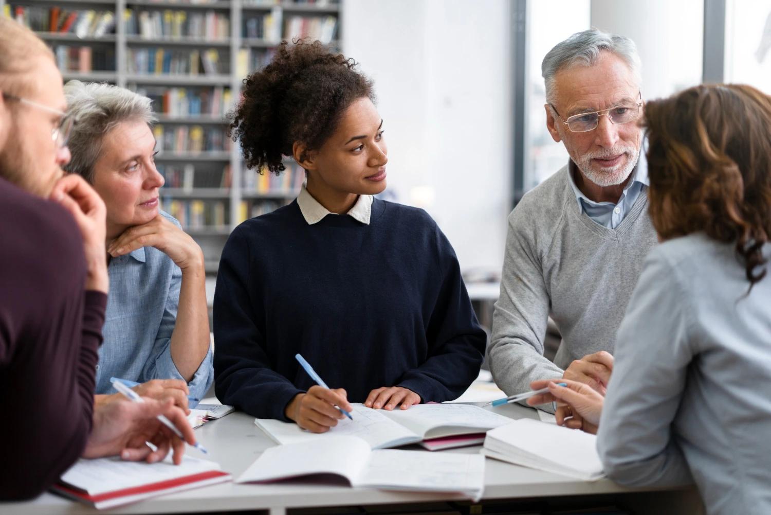 Um grupo de professores reunidos em biblioteca discutindo projeto político-pedagógico